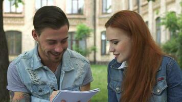 Masculin étudiant écrit quelque chose dans le sien carnet video