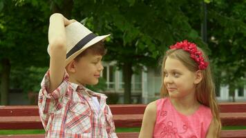 les enfants sourire pour chaque autre sur le banc video