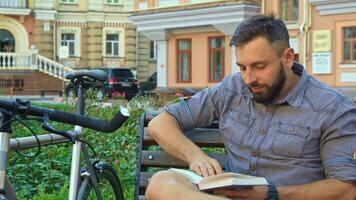 Cyclist turns the page of the book on the bench video