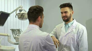 Two dentists shake hands at the office video