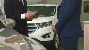 Sales manager sells car to the customer at the dealership video