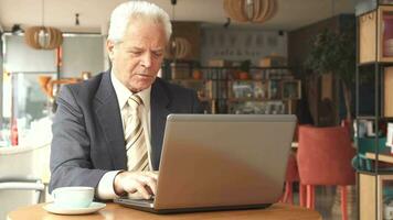 Senior businessman looking at the laptop screen video