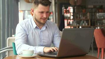 Businessman works on laptop at the cafe video