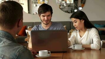 Kerl zeigt an etwas auf Laptop zu seine Freund beim das Cafe video