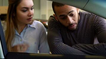 Couple looks inside the car at the dealership video