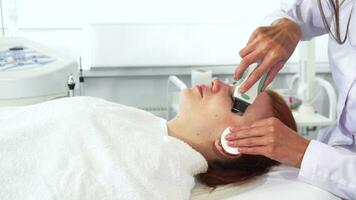 Cosmetologist uses ultrasonic machine for client's face video