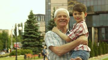 Senior man holds his grandson in his arms video