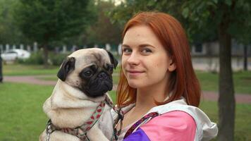 Girl holding her pug and smiling at camera video