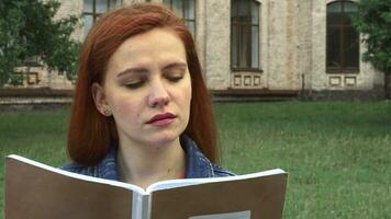 Girl reading and smiling at camera video