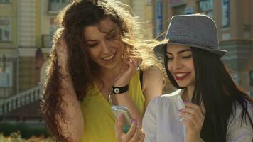 Due ragazze discutere qualcosa su smartphone video