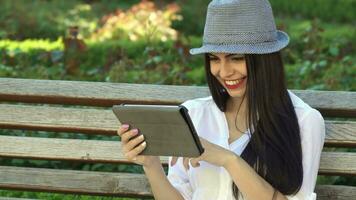 Girl uses tablet on the bench video