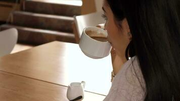 Girl takes a sip of coffee at the cafe video