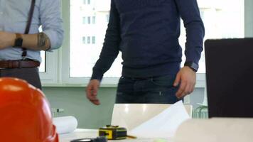 Two architects stand near the desk video