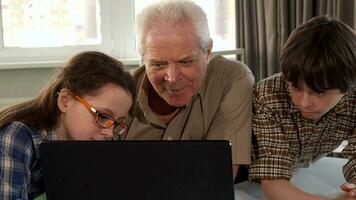 weinig meisje helpen haar opa naar type Aan laptop video