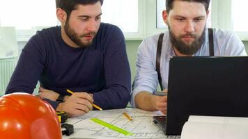 Architect points his pencil on laptop screen video