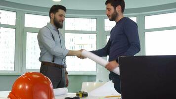 Two architects shake hands at the office video