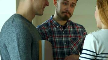 Bearded student explaines to his classmates something in his notebook video