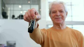 senior Mens schudt auto sleutel in zijn hand- video