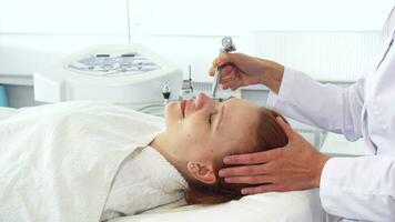 Cosmetologist using some equipment on client's face video