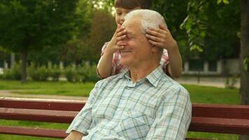 Little boy shuts grandpa's eyes with his hands video