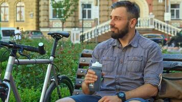 Cyclist drinks water on the bench video