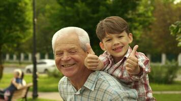Little boy shows his thumbs up on his grandpa's back video