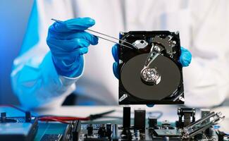 Hard disk drive on the technician's desk and a computer motherboard as a component. the concept of data, hardware, and information technology. photo