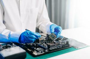 The technician is putting the CPU on the socket of the computer motherboard. electronic engineering electronic repair, electronics measuring and testing, repair photo