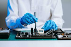 The technician repairing the motherboard in the lab with copy space. the concept of computer hardware, mobile phone, electronic, repairing, upgrade photo