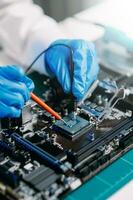The technician is putting the CPU on the socket of the computer motherboard. electronic engineering electronic repair, electronics measuring and testing, repair photo