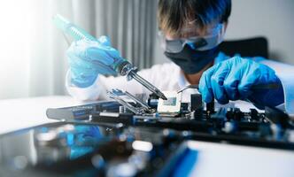 The technician is putting the CPU on the socket of the computer motherboard. electronic engineering electronic repair, electronics measuring and testing, repair photo