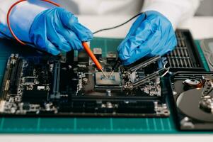 The technician is putting the CPU on the socket of the computer motherboard. electronic engineering electronic repair, electronics measuring and testing, repair photo