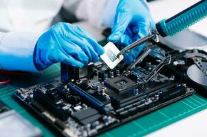 The technician repairing the motherboard in the lab with copy space. the concept of computer hardware, mobile phone, electronic, repairing, upgrade photo