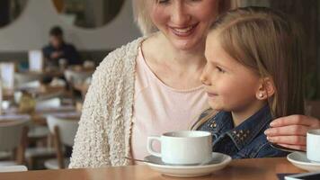 Woman shows her daughter something at the cafe video