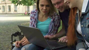 Studenten aussehen beim das Laptop auf das Bank video
