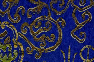 a blue and gold patterned fabric with a design on it photo