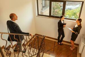 Businessman going downstairs meeting coworkers on office staircase. Business executive colleagues on stairs in corporate building. Teamwork partnership. Professional conversation in busy workplace photo