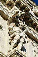 un estatua de un hombre en el lado de un edificio foto