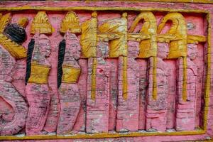 a pink wall with a wooden carving of a dragon photo