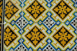 a blue and yellow tile with a design on it photo