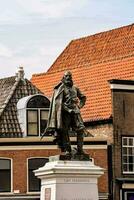 un estatua de un hombre en pie en un pedestal en frente de un edificio foto