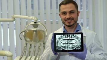 Dentist demonstrates the xray of human teeth on his tablet video