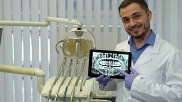 Dentist points his finger on the xray video