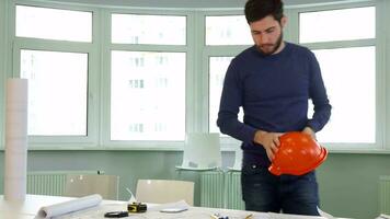 Architect puts hard hat on the desk video