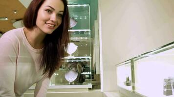 ragazza sembra a il shopping Schermo con gioielleria video