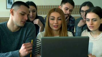 Group of students discusses something on laptop video