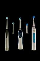 a group of four different electric toothbrushes photo