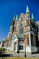 a large church with green steeples and a blue sky photo