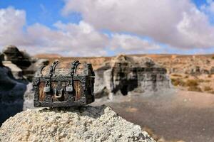 a small wooden chest sitting on top of a rock photo