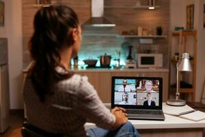 mujer de negocios teniendo un vídeo conferencia con clientela a medianoche desde hogar. corporativo reunión utilizando moderno tecnología, ordenador portátil tarde a noche , tecnología, agencia, tutor, trabajar, discusión. foto